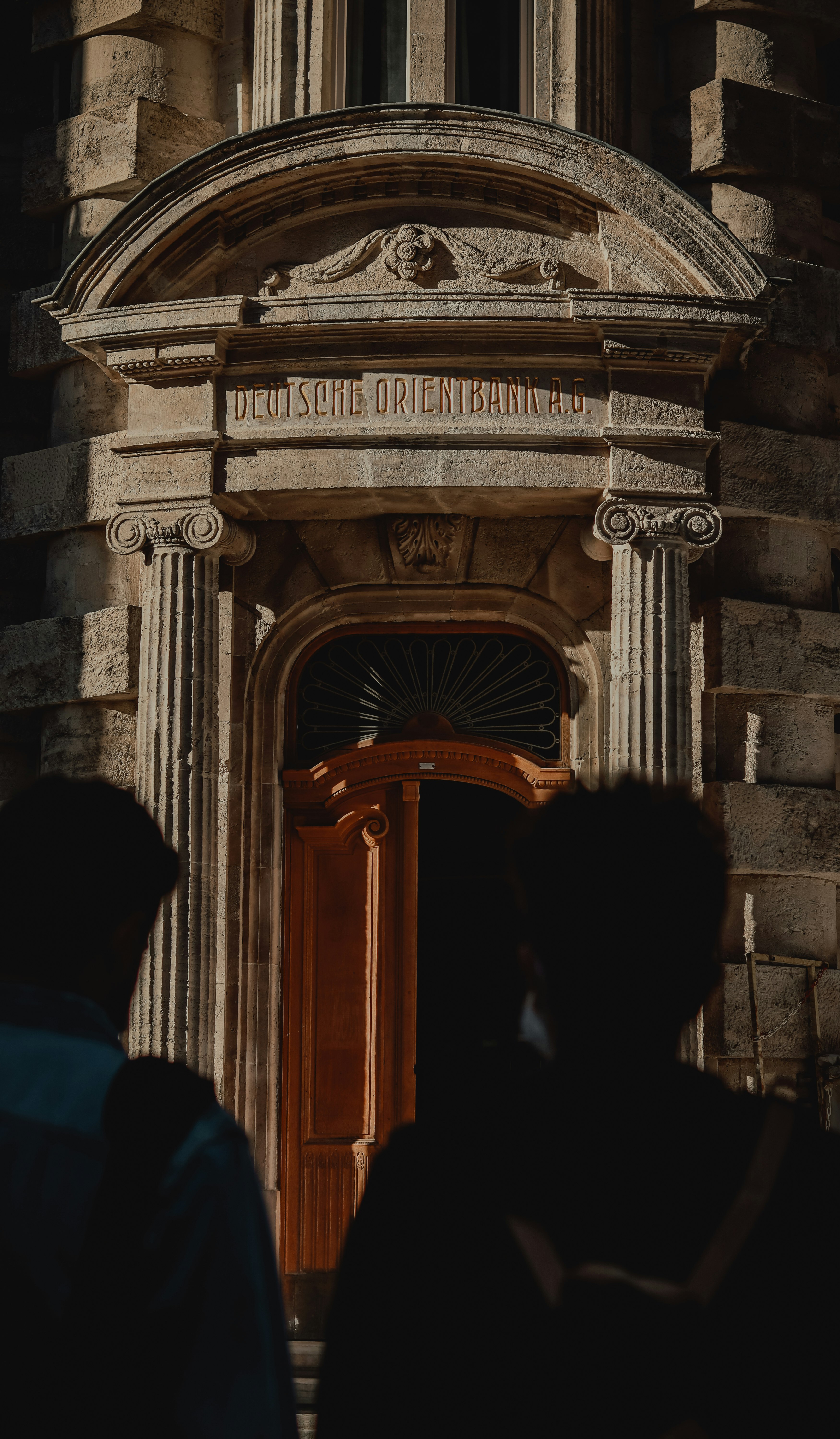 people standing in front of brown wooden door